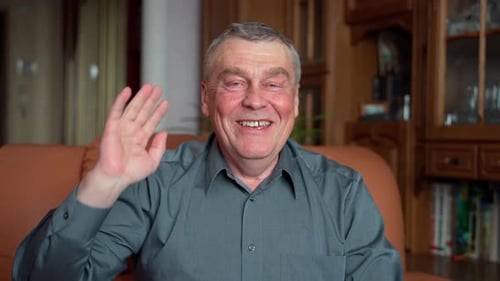 Friendly Senior Man Waving Hello Indoors