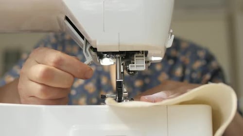 Mains travaillant avec une machine à coudre