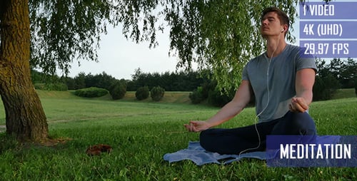 Man Meditating in Lotus Position in City Park