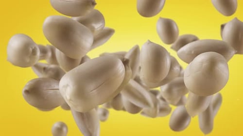 Peanuts Falling Down on Yellow Background