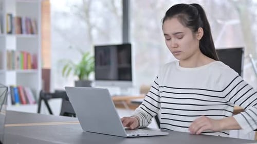 Young Asian Woman with Back Pain Using Laptop in Office