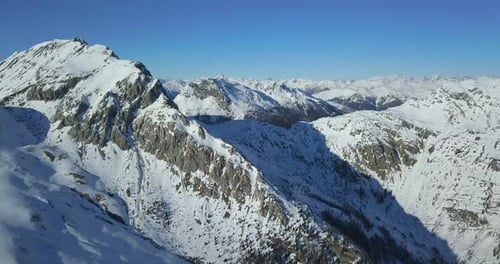 Aerial drone view of snow covered mountains in the winter.