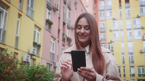 Phone Message Happy Young Woman Walking in the City