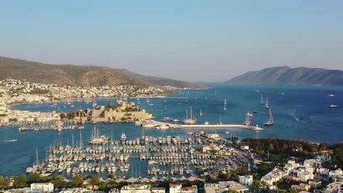 aerial drone panning across the Bodrum marina full of sail boats in the Aegean Sea as the sun sets o