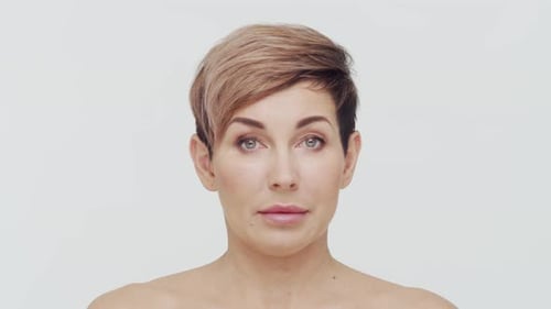 Close-up of middle aged mature woman over white background.