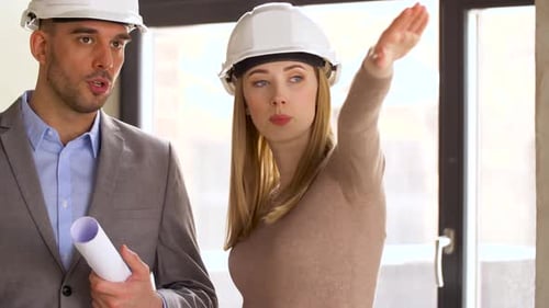 Architects with Blueprint and Helmets at Office 61