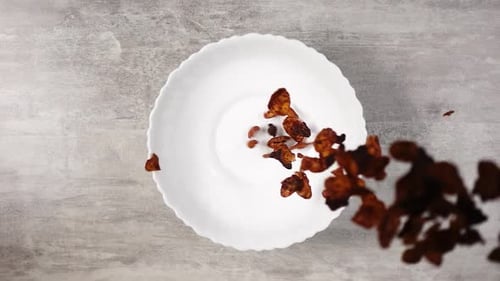 Cornflakes Pouring into a White Bowl Overhead Shot