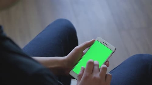 Closeup of Male Hands Holding Smart Phone with Green Screen Prekeyed for Effects. Useful Mobile