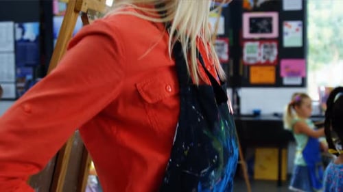 Smiling Teacher in Classroom with Young Art Students