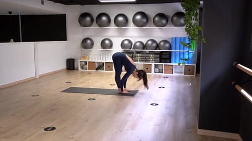 Femme faisant le cycle de salutation au soleil des asanas dans la salle de gym
