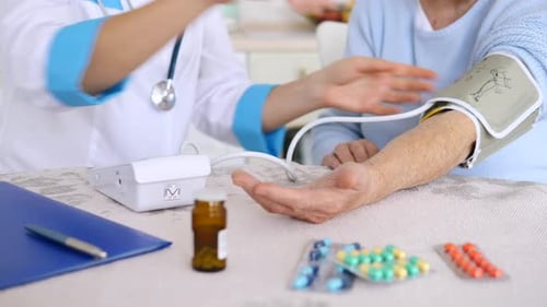 Doctor Checking Old Woman Patient Arterial Blood Pressure. Health Care.