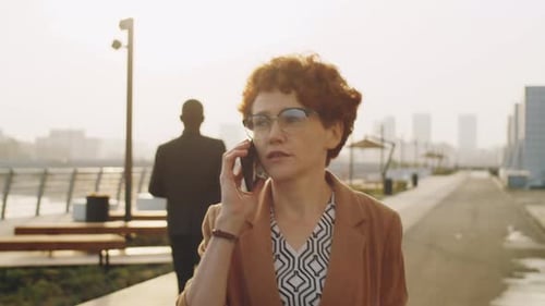 Businesswoman Walking on Street and Having Phone Talk