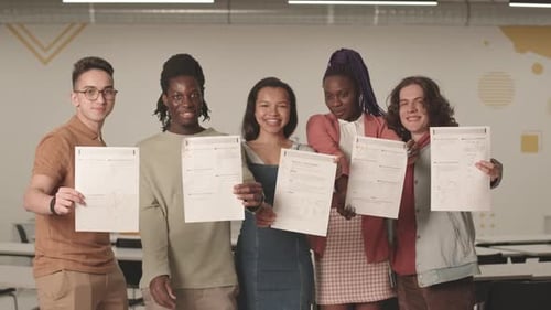 Étudiants multiethniques présentant des copies d'examen notées