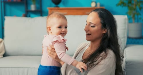 Loving Mother Holding Adorable Infant at Home