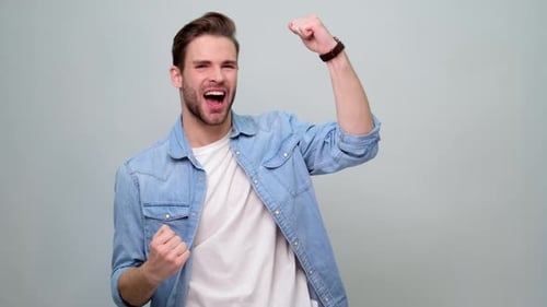 Man Celebrates With Fists Raised in Triumph