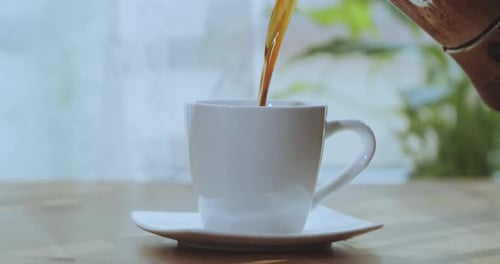 Coffee Pouring Into Steaming Mug On Table