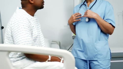 Nurse Consults with Patient in Hospital Setting