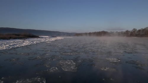 Aerial Drone Close Up View on the Frozen River with Haze and Floating Ice Early Morning