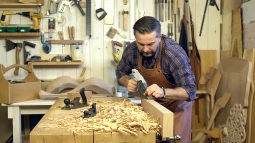 Cabinetmaker Planes Solid Wood in his Workshop