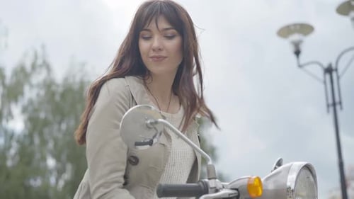 Stylish Brunette Woman Posing with Vintage Scooter