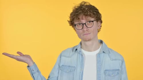 Smiling Man Posing with Hand Outstretched on Yellow