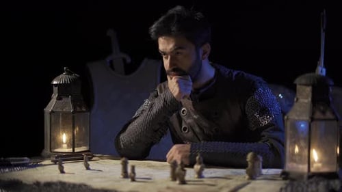 Man in Chainmail Plays Chess by Lantern Light