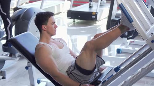 Man Doing Leg Press Exercise in Gym