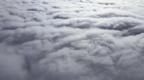 Aerial View From Airplane Window at High Altitude of Earth Covered with Puffy Cumulus Clouds Forming