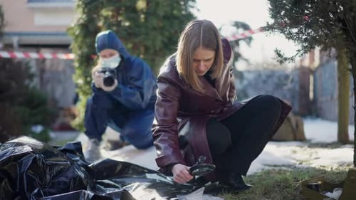 Woman Detective Examines Crime Scene with Magnifying Glass
