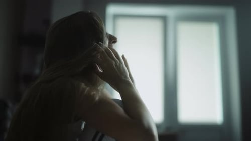 Distressed Woman Crying in a Dark Room