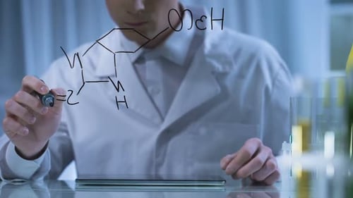 Chemist Finishing Formula on Glass Board, Entering Research Result in Tablet