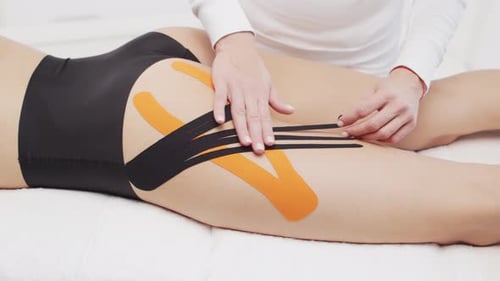 Woman Receiving Athletic Taping on Thigh