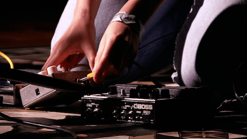 Man Adjusting Guitar Effects Pedals in Studio