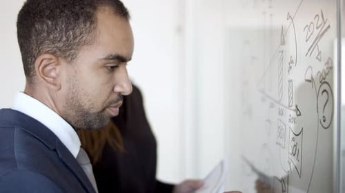 Tableau de dessin d'homme d'affaires sérieux sur panneau de verre
