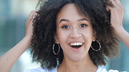 Young Woman Celebrates Success Outdoors With Big Smile