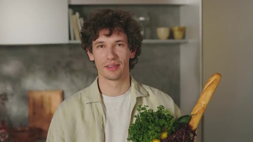 Handsome Man Standing on Kitchen with Grocery Bag