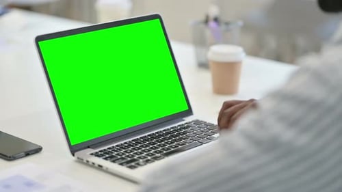 Rear View of African Man Using Laptop with Green Chroma Key Screen