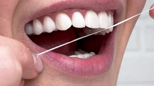Closeup Woman Flossing perfekte weiße Zähne mit Zahnseide Zahnpflege Hygiene Zahnreinigung Routine und