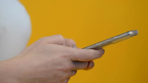 Hand Using Smartphone, Bright Yellow Background