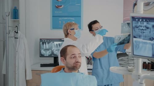 Dental Team Analyzing Patient X-ray in Office