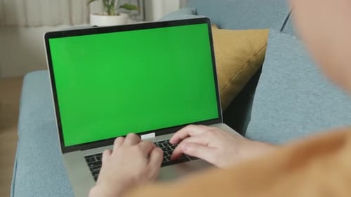 Male Working On Laptop With Green Screen Display