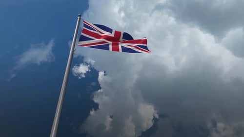 Waving Union Jack Flag Against Dynamic Sky