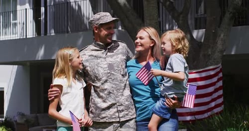 Portrait of caucasian military man in uniform and his family smiling in the garden