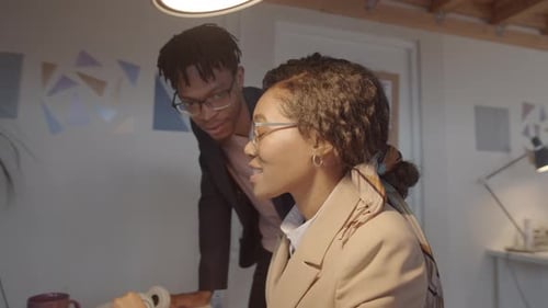 Afro-American Male and Female Colleagues Talking in Office
