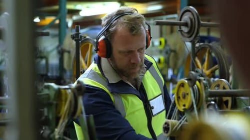 Man Works at Industrial Factory Equipment