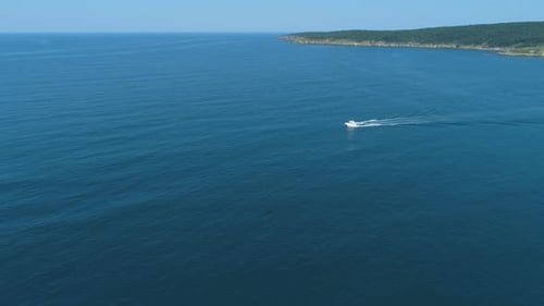 White Boat Quickly Floating on the Calm Water Surface and Leaving a Trail on the Sea