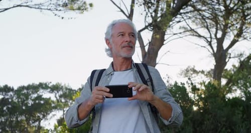Man Taking Photos Outdoors with Smartphone