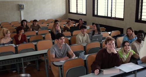 Multiethnic students working with laptop computers inside classroom at school university