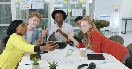 Multiethnic Friends Sitting at the Office Table and Doing Group Photo on Mobile