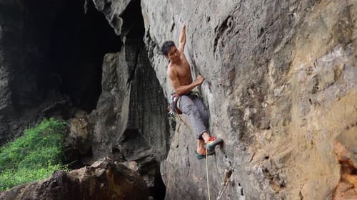 Muscular Man Climbing Up On Rocky Wall